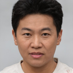 Joyful asian adult male with short  black hair and brown eyes