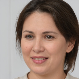 Joyful white adult female with medium  brown hair and brown eyes