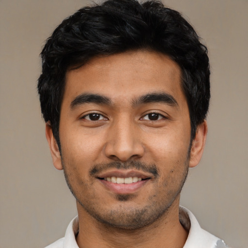 Joyful latino young-adult male with short  black hair and brown eyes