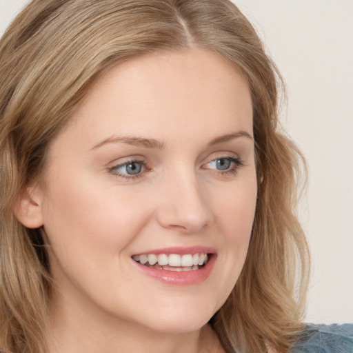 Joyful white young-adult female with long  brown hair and blue eyes