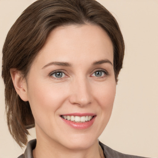 Joyful white young-adult female with medium  brown hair and grey eyes