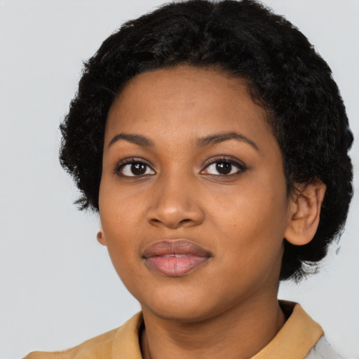 Joyful black young-adult female with short  black hair and brown eyes