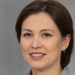 Joyful white adult female with medium  brown hair and brown eyes