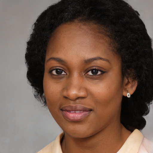Joyful black young-adult female with medium  black hair and brown eyes