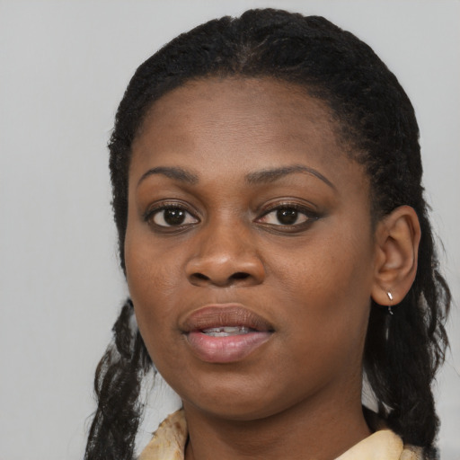 Joyful black young-adult female with long  black hair and brown eyes
