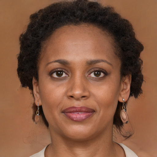 Joyful black adult female with medium  brown hair and brown eyes