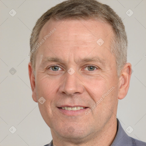 Joyful white middle-aged male with short  brown hair and grey eyes