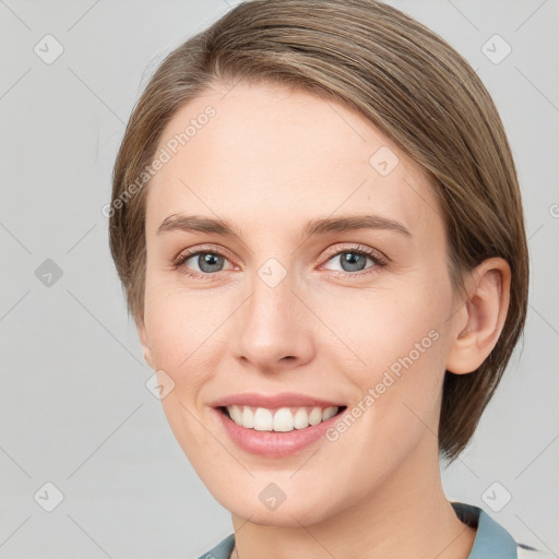 Joyful white young-adult female with medium  brown hair and grey eyes