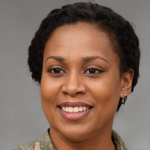 Joyful black adult female with short  brown hair and brown eyes