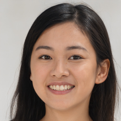 Joyful asian young-adult female with long  brown hair and brown eyes