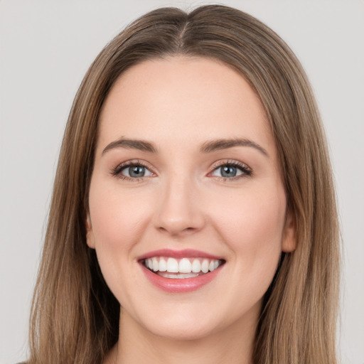 Joyful white young-adult female with long  brown hair and green eyes