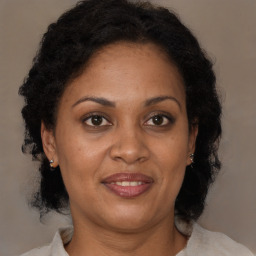 Joyful black adult female with medium  brown hair and brown eyes