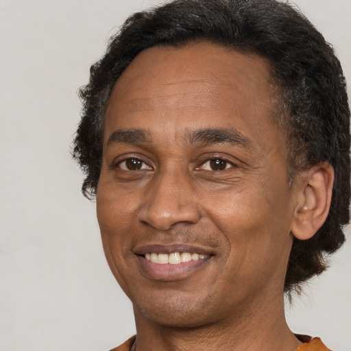 Joyful black adult male with short  brown hair and brown eyes