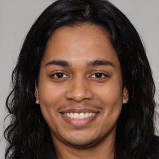 Joyful latino young-adult male with long  black hair and brown eyes