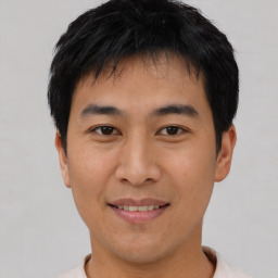 Joyful asian young-adult male with short  black hair and brown eyes