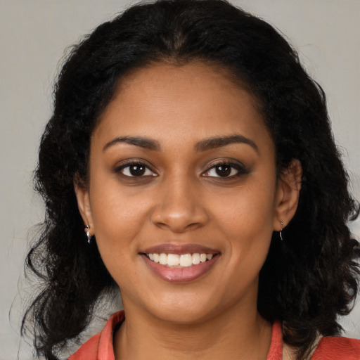 Joyful black young-adult female with long  black hair and brown eyes