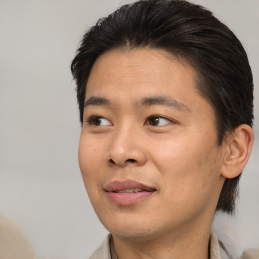 Joyful asian adult male with short  brown hair and brown eyes