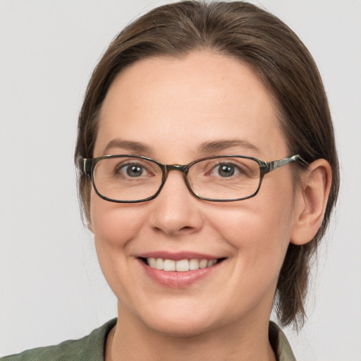 Joyful white young-adult female with medium  brown hair and grey eyes