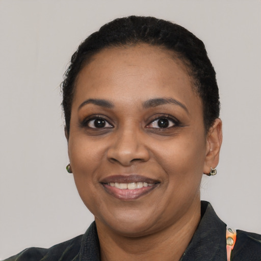 Joyful black young-adult female with short  black hair and brown eyes