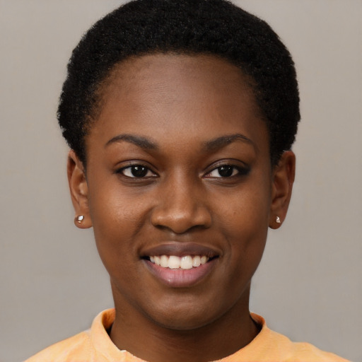 Joyful black young-adult female with short  black hair and brown eyes