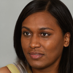 Joyful black young-adult female with long  brown hair and brown eyes