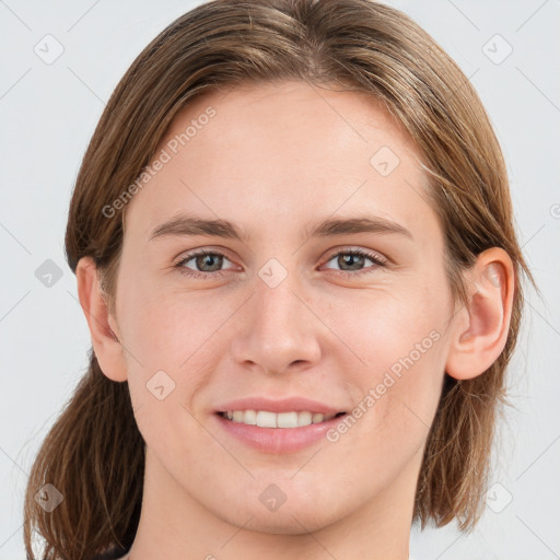 Joyful white young-adult female with medium  brown hair and grey eyes