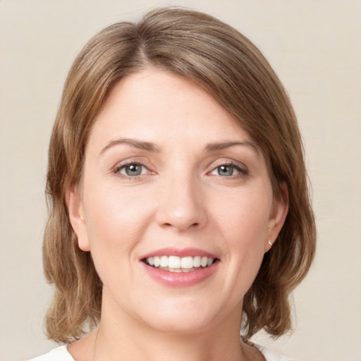 Joyful white young-adult female with medium  brown hair and green eyes