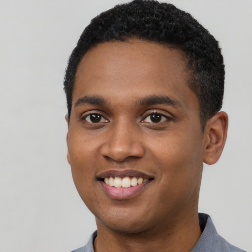 Joyful black young-adult male with short  black hair and brown eyes