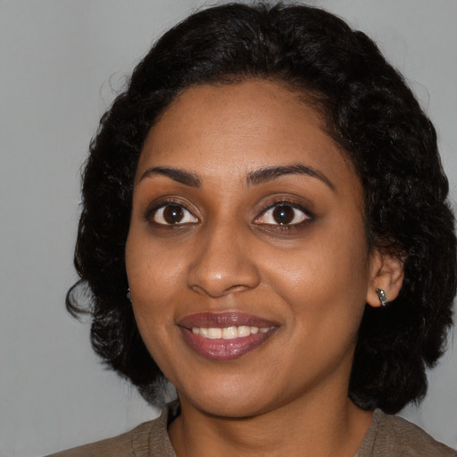 Joyful black young-adult female with medium  black hair and brown eyes