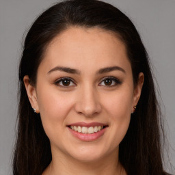 Joyful white young-adult female with long  brown hair and brown eyes