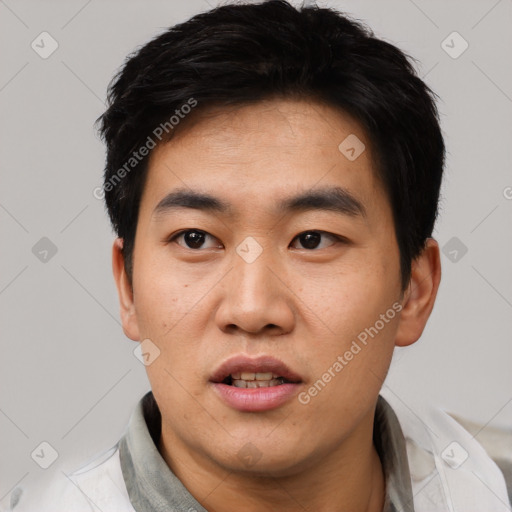 Joyful asian young-adult male with short  black hair and brown eyes