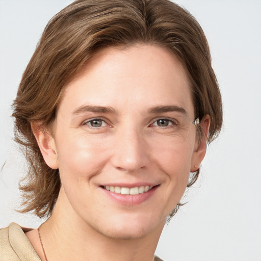 Joyful white young-adult female with medium  brown hair and grey eyes