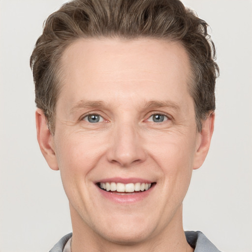 Joyful white adult male with short  brown hair and grey eyes