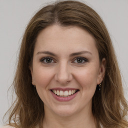 Joyful white young-adult female with long  brown hair and grey eyes