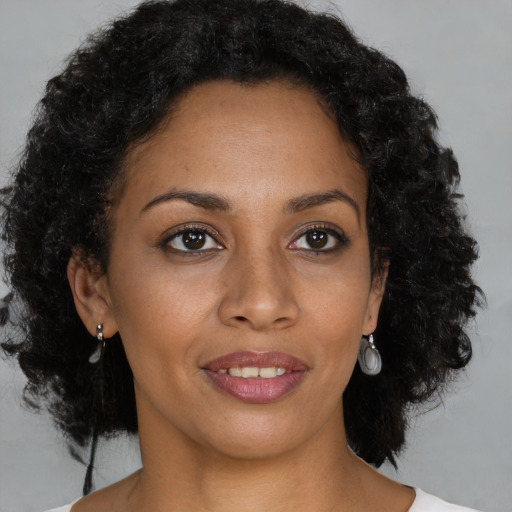 Joyful black young-adult female with medium  brown hair and brown eyes