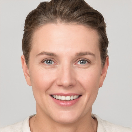 Joyful white young-adult female with short  brown hair and grey eyes