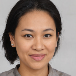 Joyful latino adult female with medium  brown hair and brown eyes