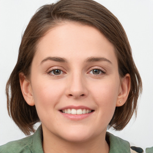 Joyful white young-adult female with medium  brown hair and green eyes