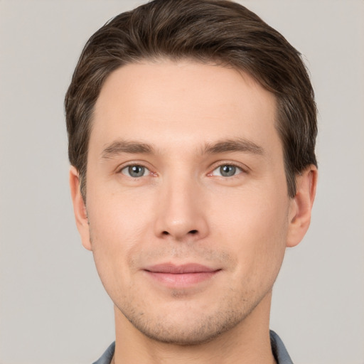 Joyful white young-adult male with short  brown hair and grey eyes