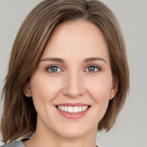 Joyful white young-adult female with medium  brown hair and green eyes