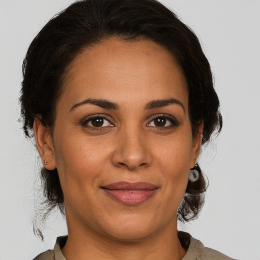 Joyful latino adult female with medium  brown hair and brown eyes