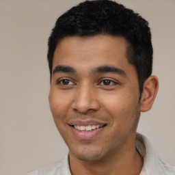 Joyful latino young-adult male with short  black hair and brown eyes