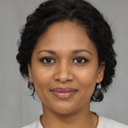 Joyful black young-adult female with medium  brown hair and brown eyes