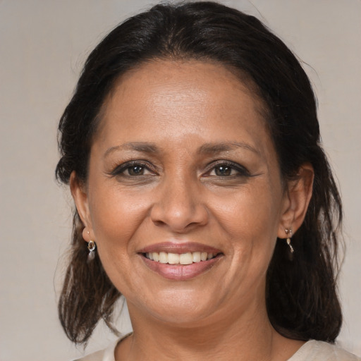 Joyful black adult female with medium  brown hair and brown eyes
