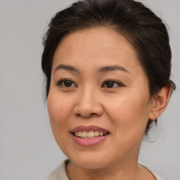 Joyful asian adult female with medium  brown hair and brown eyes