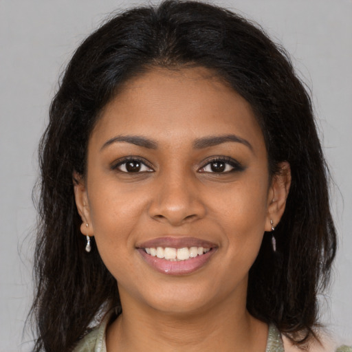 Joyful black young-adult female with long  brown hair and brown eyes