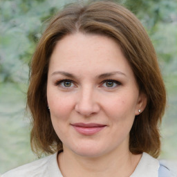 Joyful white young-adult female with medium  brown hair and green eyes