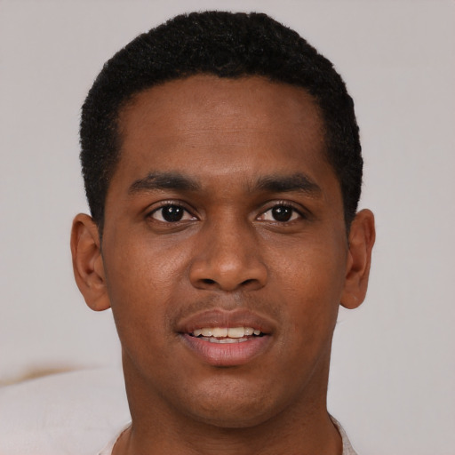 Joyful black young-adult male with short  brown hair and brown eyes
