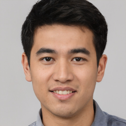 Joyful asian young-adult male with short  black hair and brown eyes