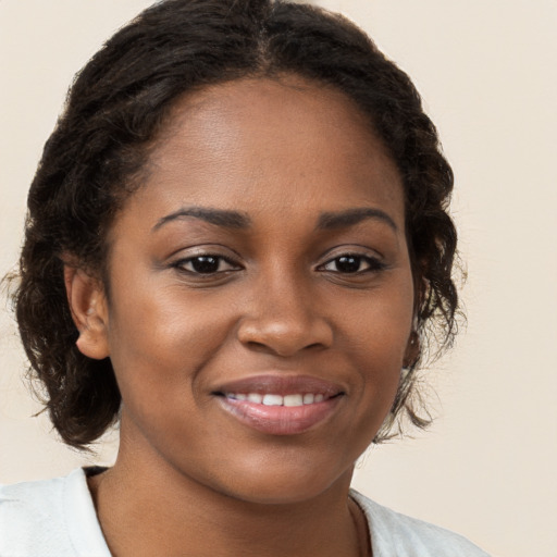 Joyful black young-adult female with medium  brown hair and brown eyes